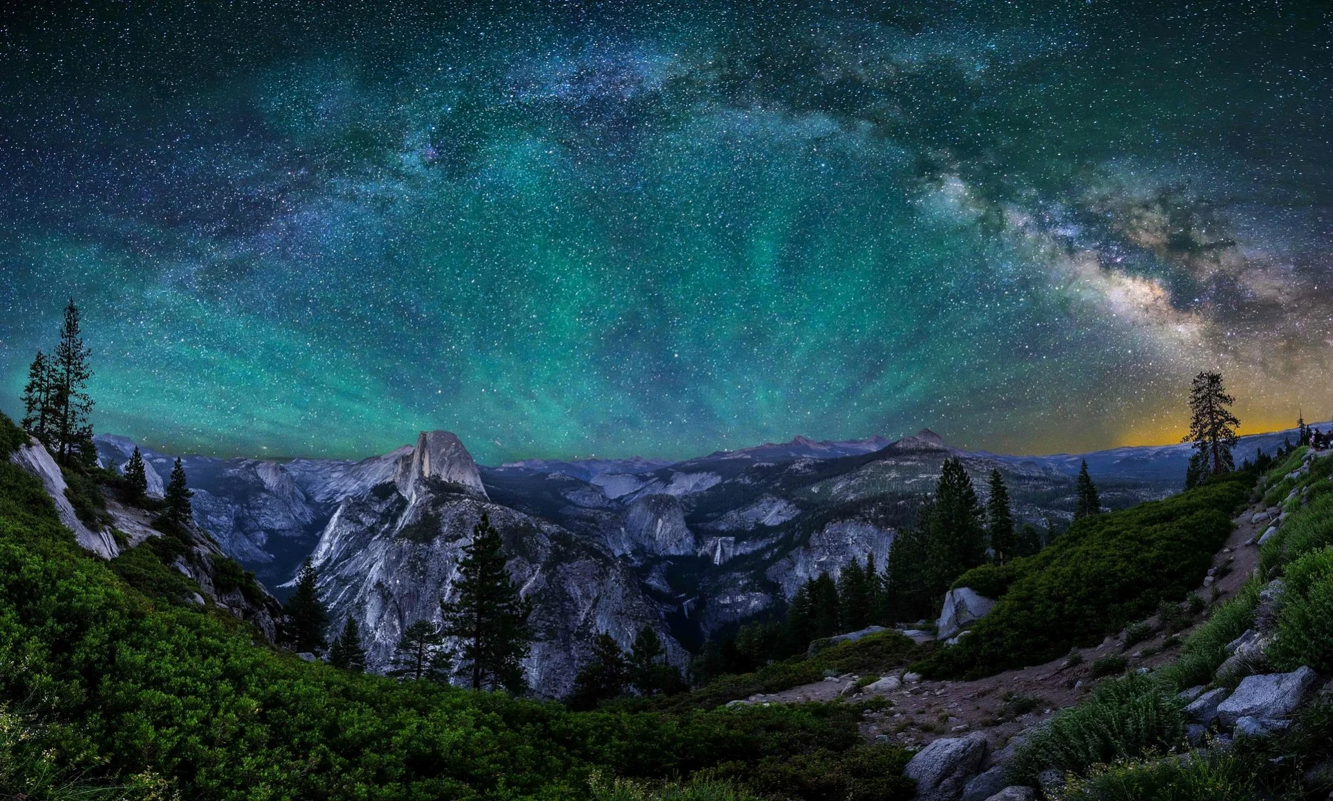 The Milky Way above Yosemite granite peaks and evergreen trees