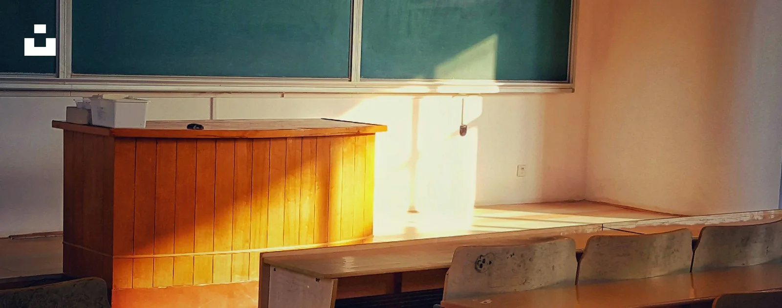 Natural light across an empty classroom with desks and chairs