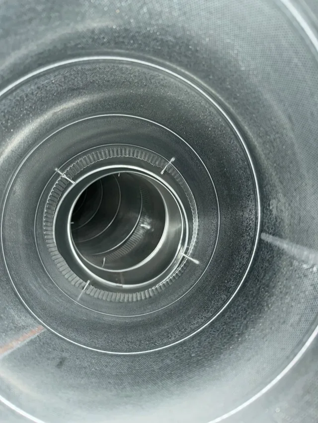 Well-lit close view inside a round metal air duct from the PAC project photo library